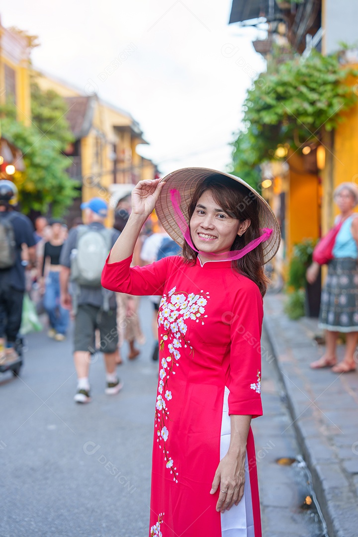 mulher feliz usando vestido vietnamita Ao Dai, viajante asiático passeando em Hoi An, cidade antiga no centro do Vietnã.