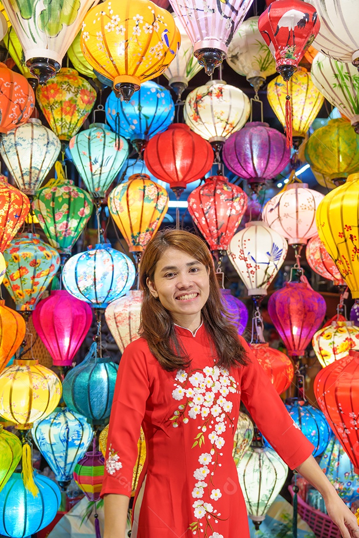 mulher feliz usando vestido vietnamita Ao Dai com lanternas coloridas, passeio turístico em Hoi Uma cidade antiga no centro do Vietnã.