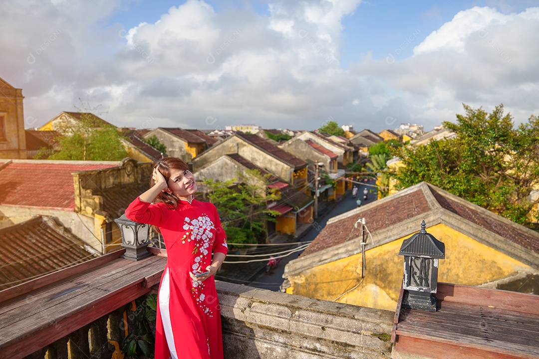 mulher feliz usando vestido vietnamita Ao Dai com lanternas coloridas, passeio turístico em Hoi Uma cidade antiga no centro do Vietnã.