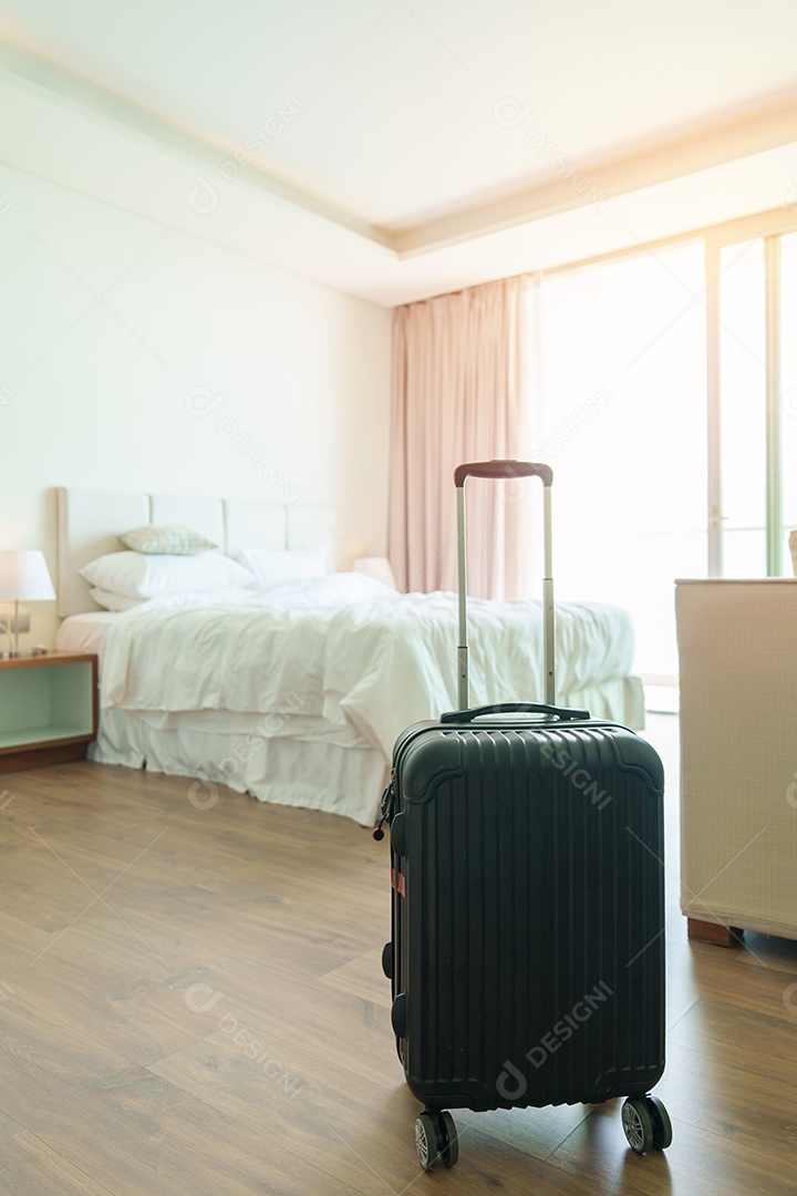 Bagagem preta com chapéu no quarto de hotel moderno após a abertura da porta.