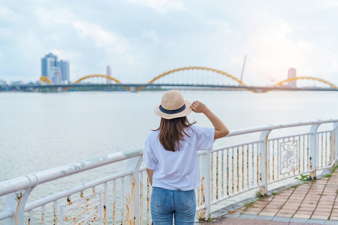 Mulher viajante visitando a cidade de Da Nang. Turismo turístico a vista do rio com ponte do dragão.