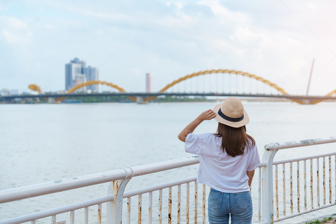 Mulher viajante visitando a cidade de Da Nang. Turismo turístico a vista do rio com ponte do dragão.