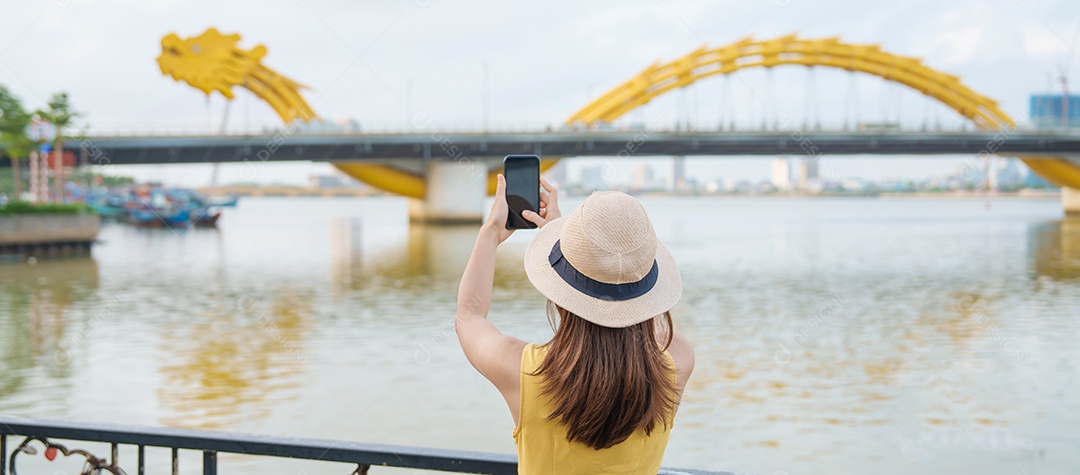 Mulher Viajante com vestido amarelo visitando Da Nang.