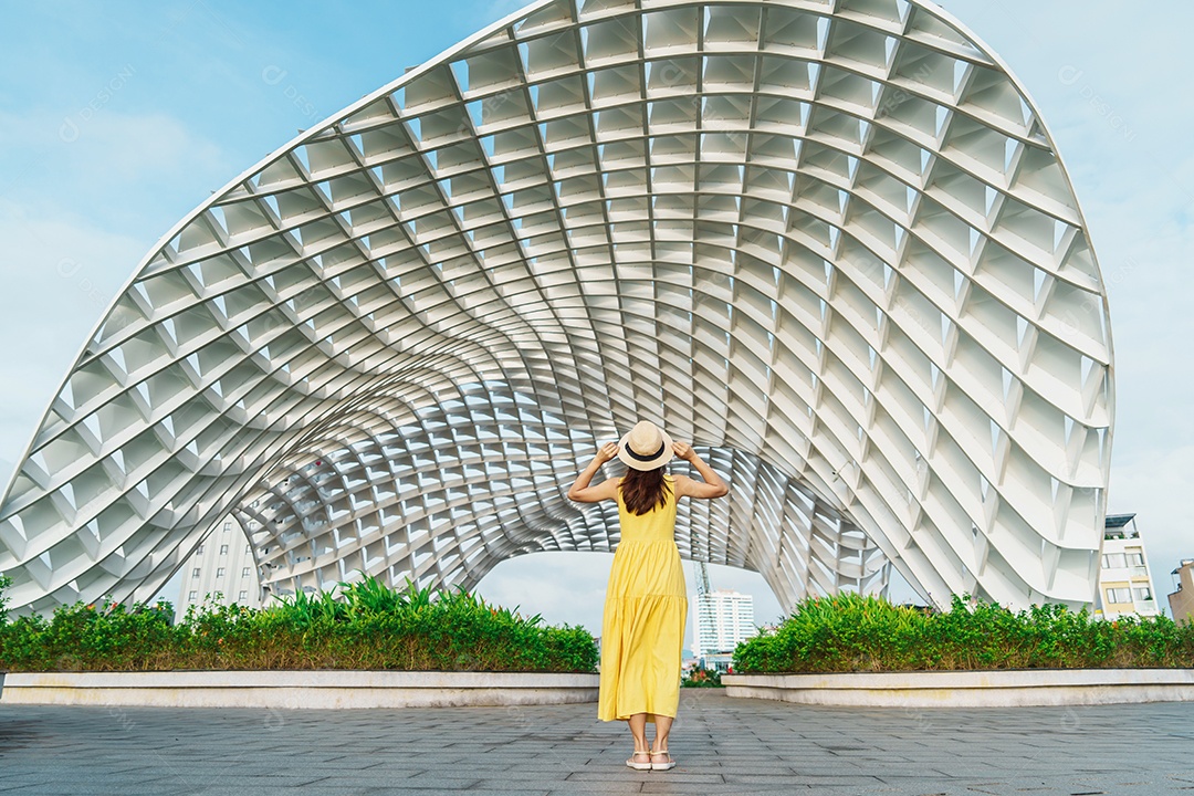 Mulher Viajante com vestido amarelo visitando a cidade de Da Nang.