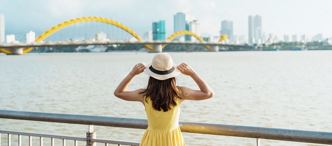 Mulher Viajante com vestido amarelo visitando a cidade de Da Nang.