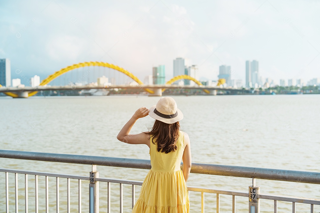 Mulher Viajante com vestido amarelo visitando a cidade de Da Nang.