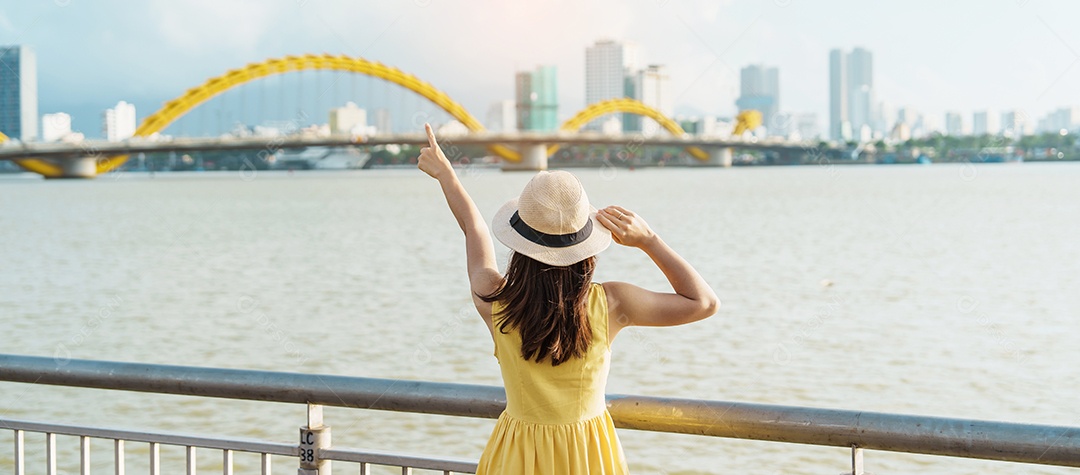 Mulher Viajante com vestido amarelo visitando a cidade de Da Nang.