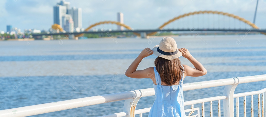 Mulher Viajante com vestido azul visitando a cidade de Da Nang.