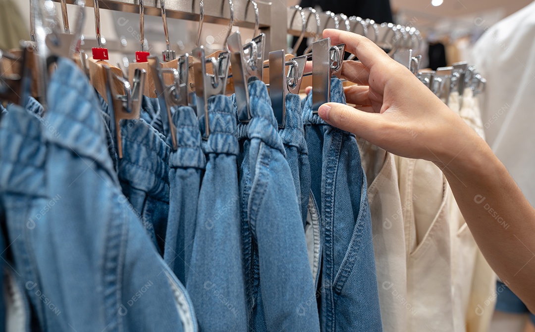 Mulher comprando calças jeans em loja de roupas