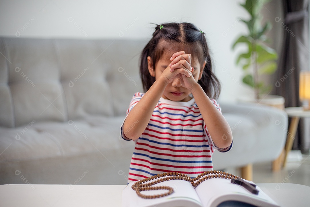 Conceito cristão. Menina asiática rezando retendo a cruz. Conceitos de esperança, fé, cristianismo, religião