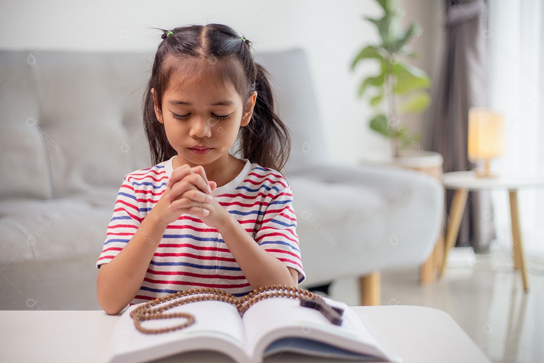 Conceito cristão. Menina asiática rezando retendo a cruz. Conceitos de esperança, fé, cristianismo, religião