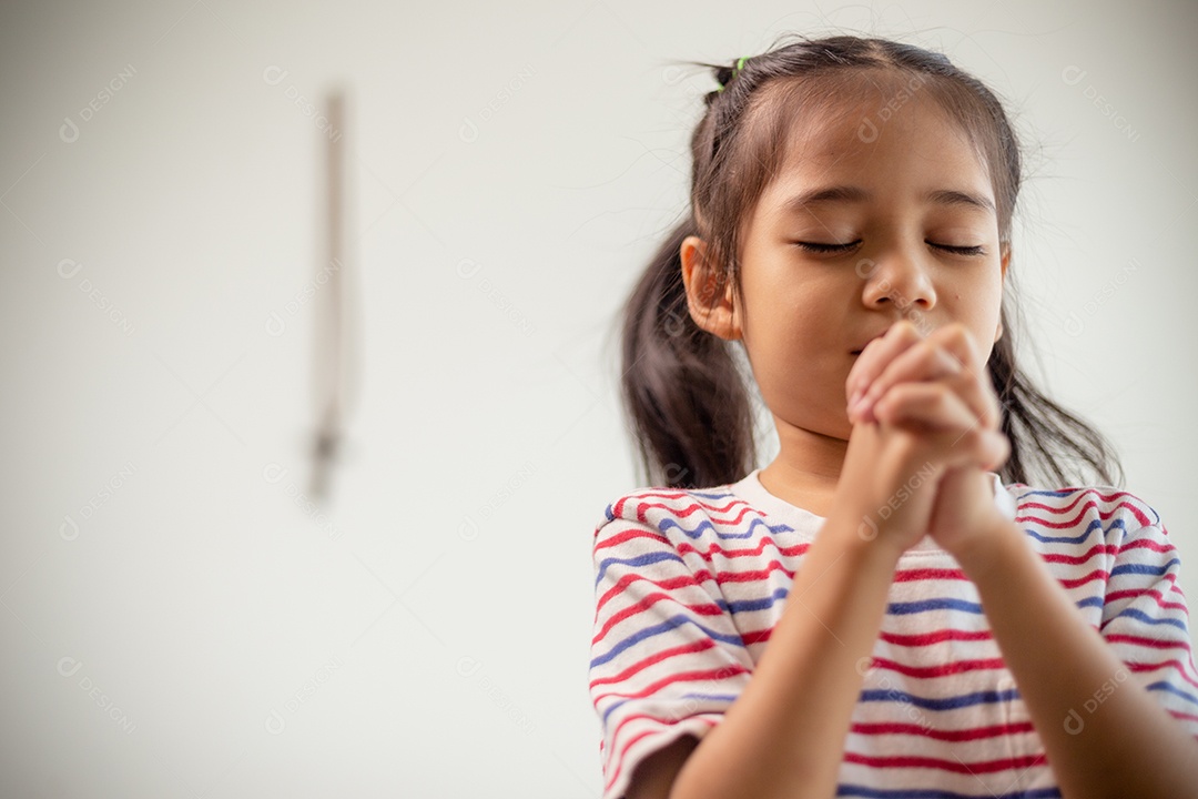 Conceito cristão. Menina asiática rezando retendo a cruz. Conceitos de esperança, fé, cristianismo, religião