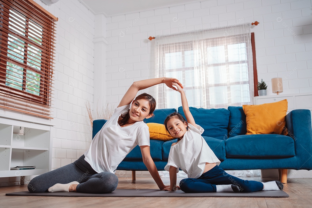 Mãe e filha se exercitando juntas e felizes em casa.