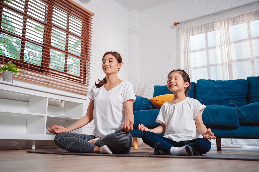 Mãe e filha se exercitando juntas e felizes em casa.