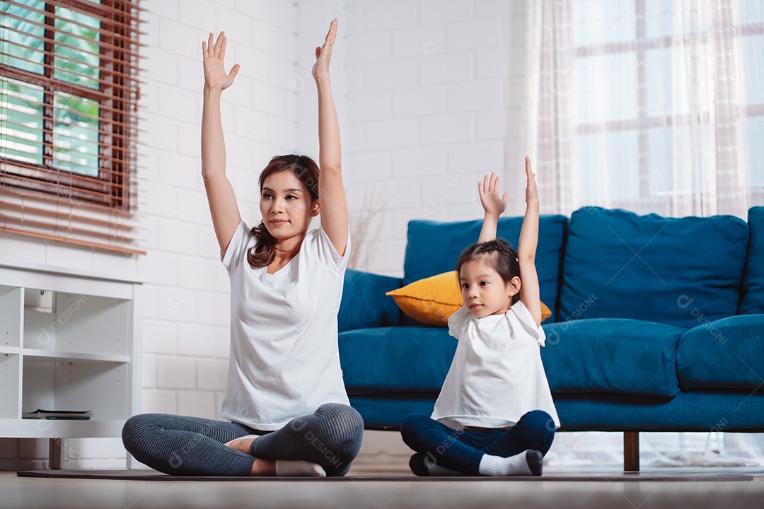 Mãe e filha se exercitando juntas e felizes em casa.