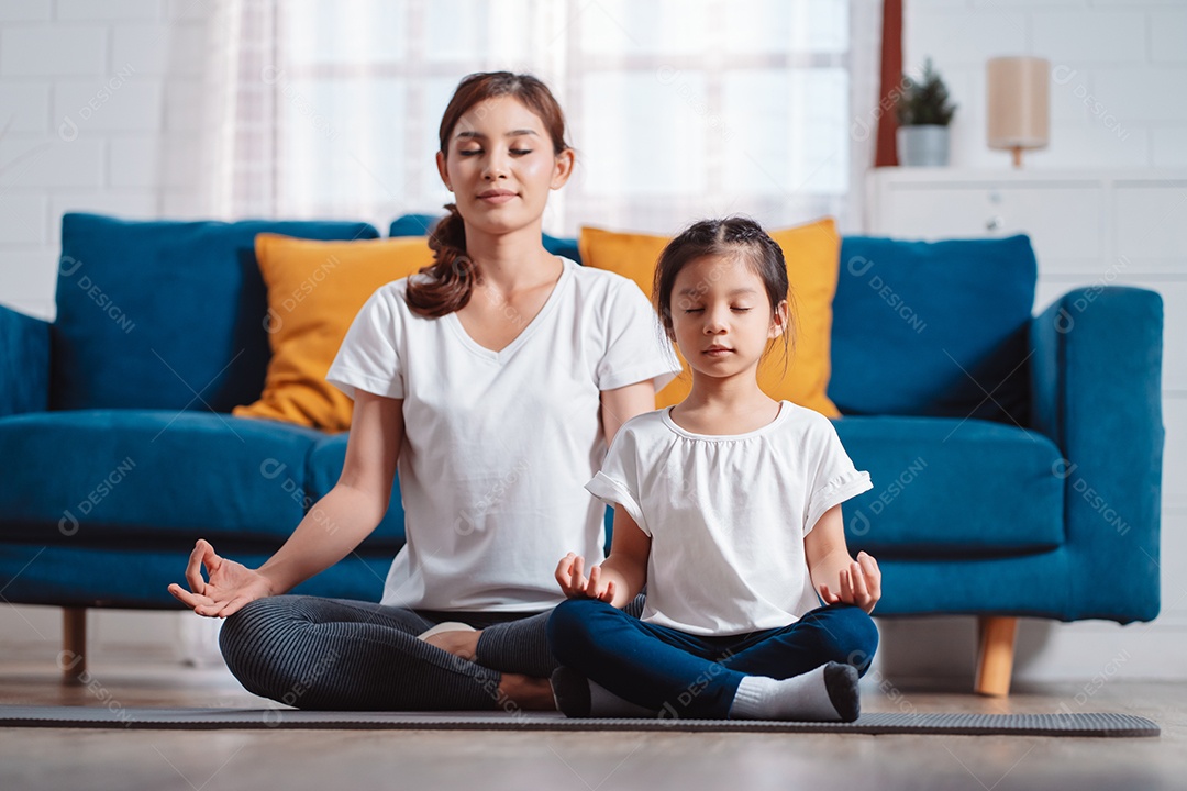 Mãe e filha se exercitando juntas e felizes em casa.