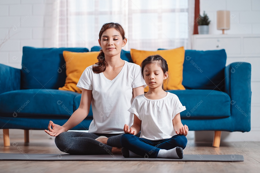 Mãe e filha se exercitando juntas e felizes em casa.