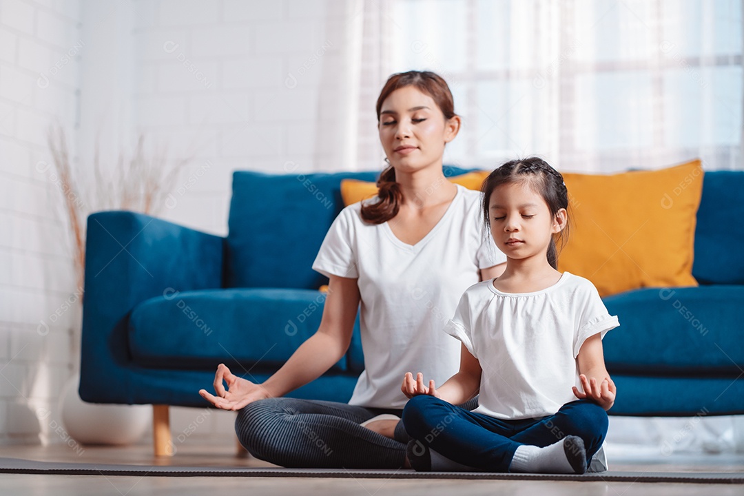 Mãe e filha se exercitando juntas e felizes em casa.