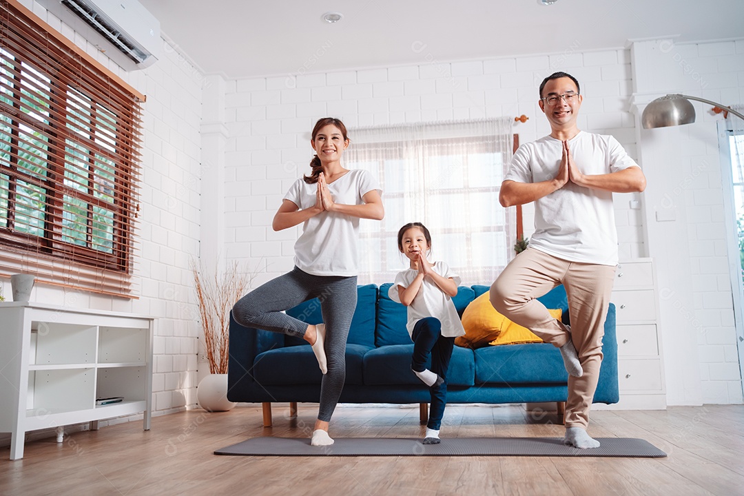 Família composta por pais e filhas se exercitando juntos em casa.