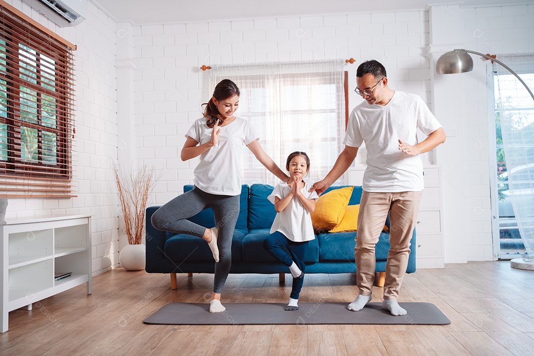 Família composta por pais e filhas se exercitando juntos em casa.