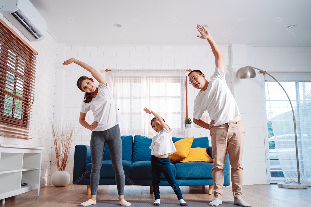 Família composta por pais e filhas se exercitando juntos em casa.