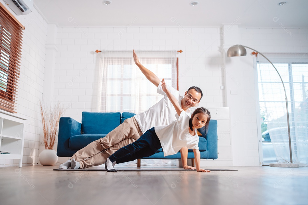 Pai e filha se exercitando juntos e felizes em casa.