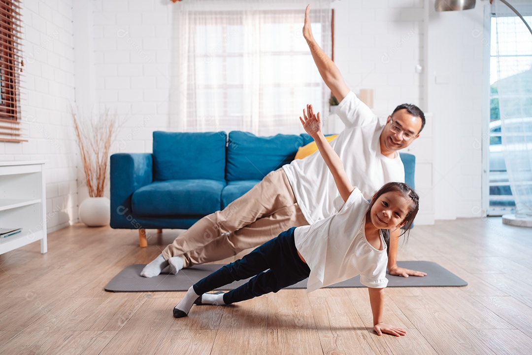 Pai e filha se exercitando juntos e felizes em casa.