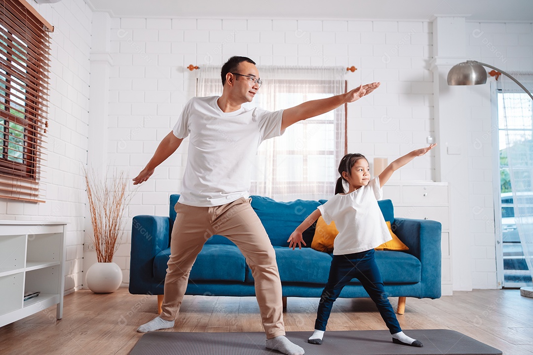 Pai e filha se exercitando juntos e felizes em casa.
