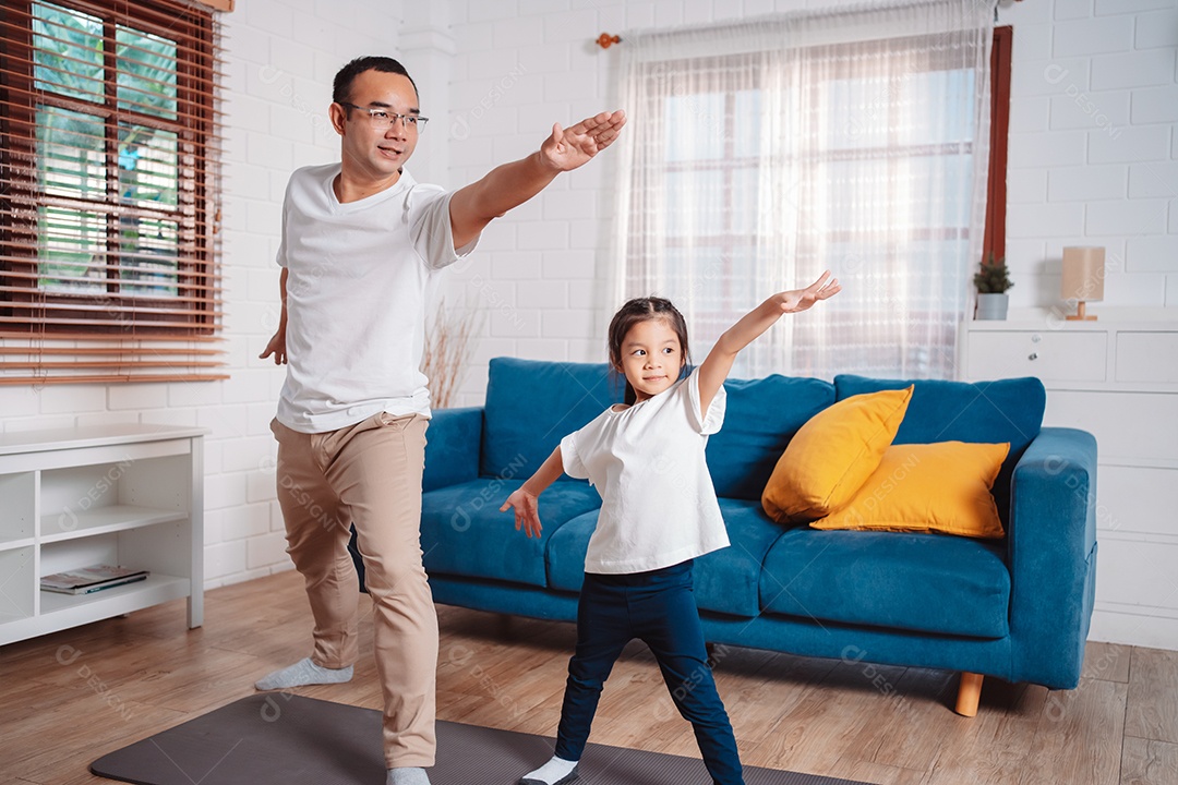 Pai e filha se exercitando juntos e felizes em casa.