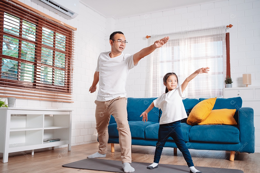 Pai e filha se exercitando juntos e felizes em casa.