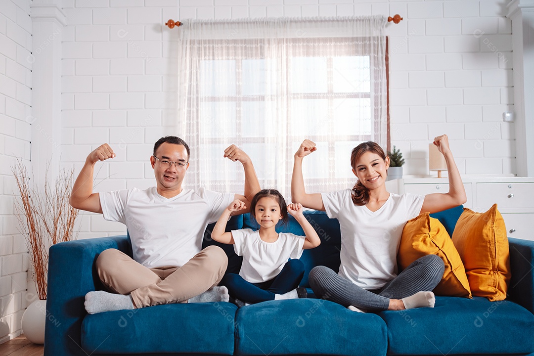 Família composta por pais e filhas se exercitando juntos em casa.