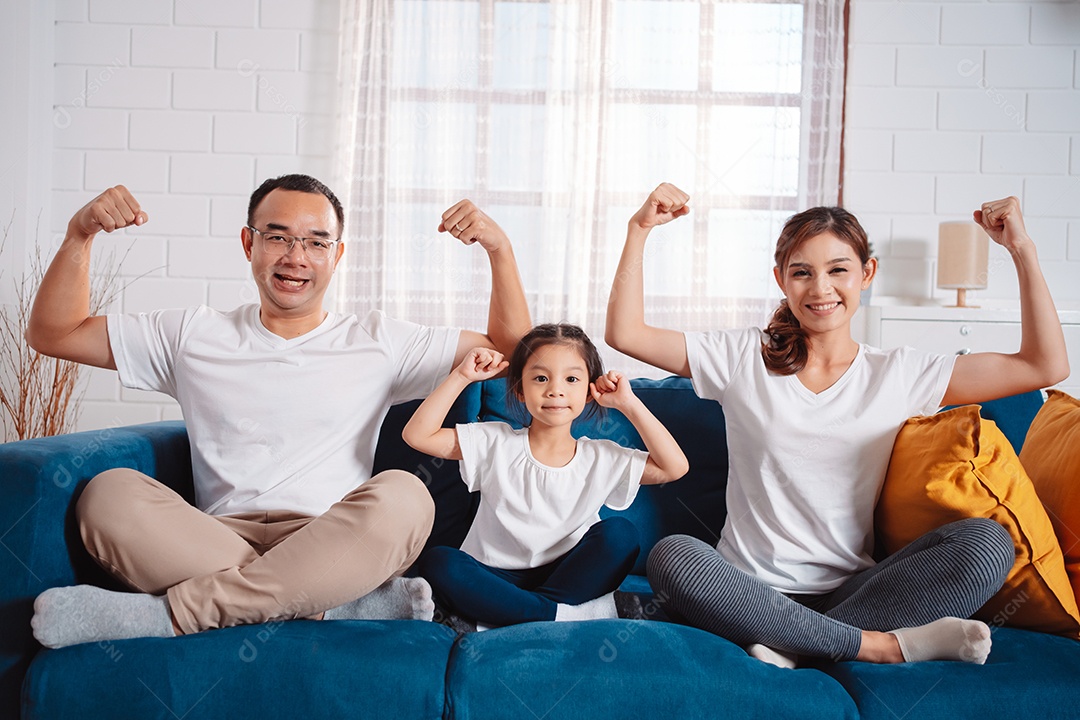 Família composta por pais e filhas se exercitando juntos em casa.