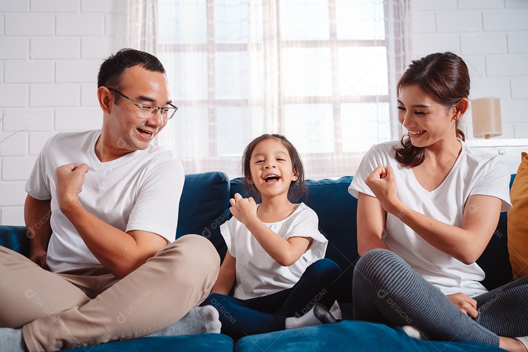 Família composta por pais e filhas se exercitando juntos em casa.