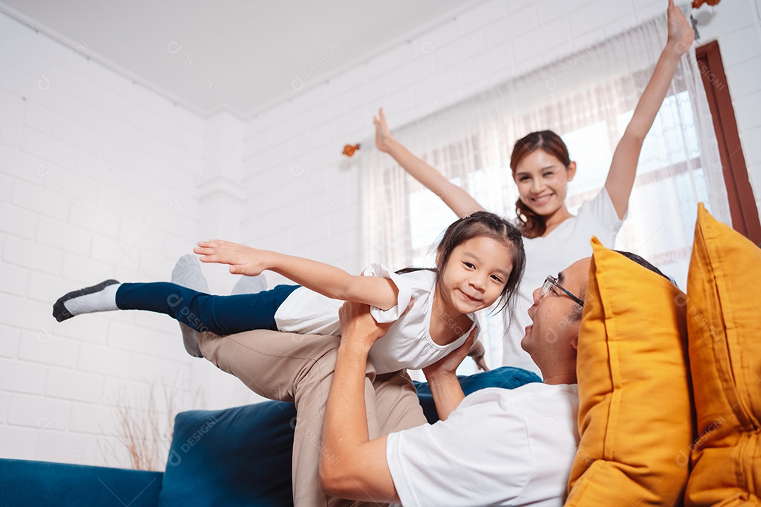 Família composta por pais e filhas se exercitando juntos em casa.