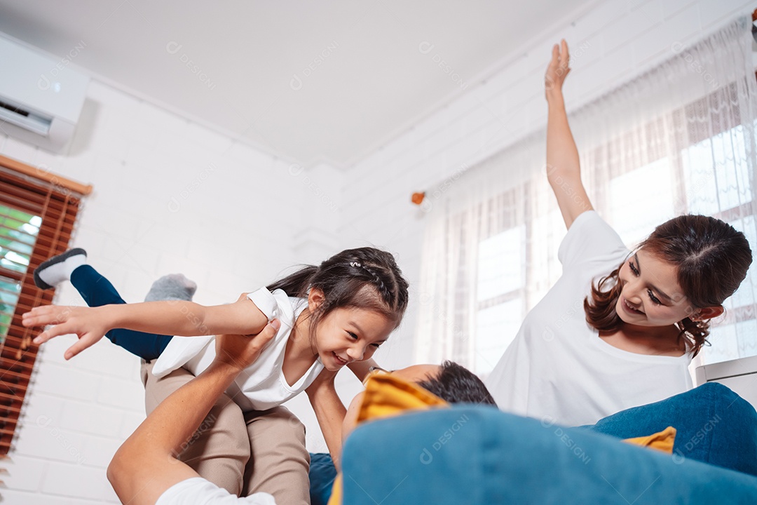Família composta por pais e filhas se exercitando juntos em casa.
