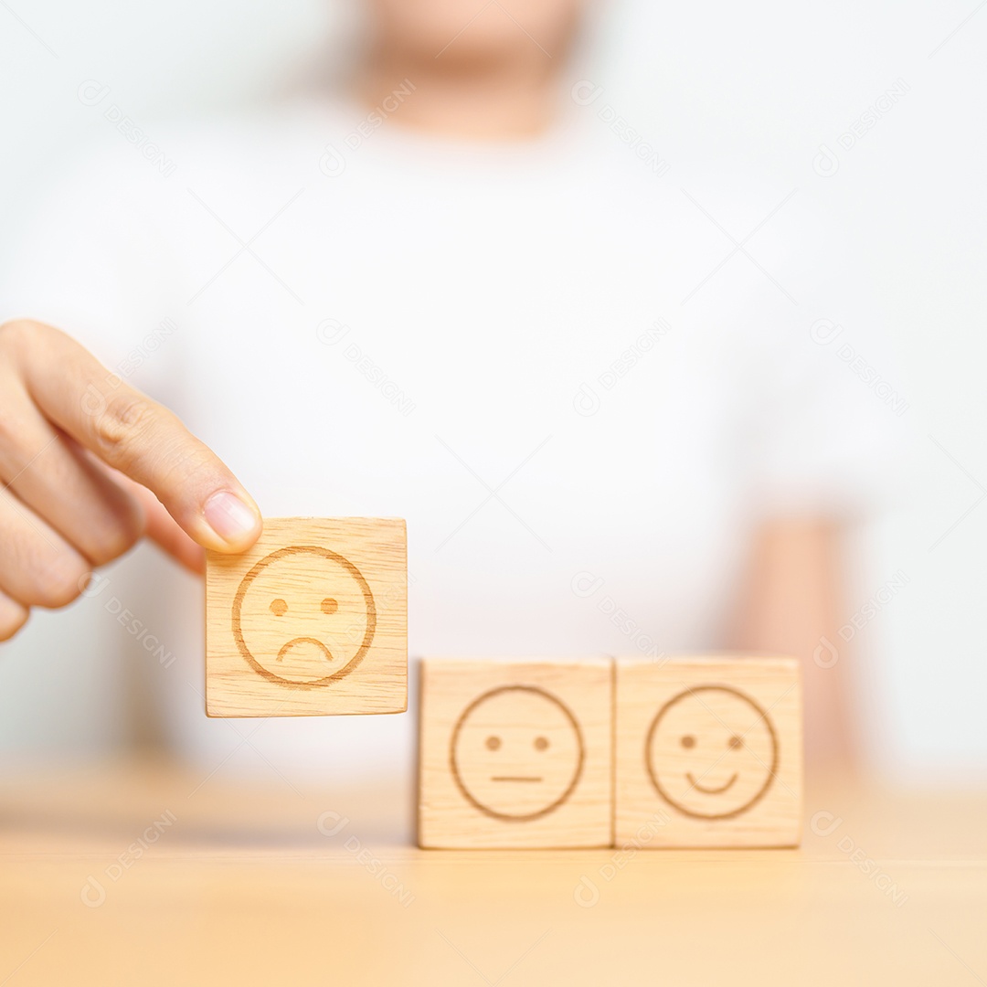 Mão escolhendo o rosto sorridente do bloco Emoção para avaliação do cliente, boa experiência, feedback positivo, satisfação