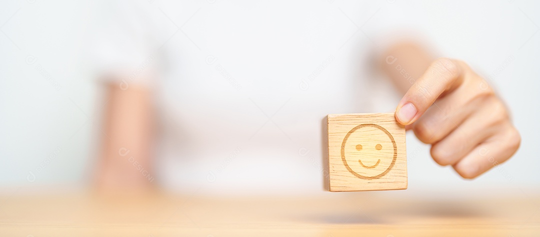 Mão escolhendo rosto feliz do bloco Emotion para avaliação do cliente, boa experiência, feedback positivo, satisfação, pesquisa, avaliação