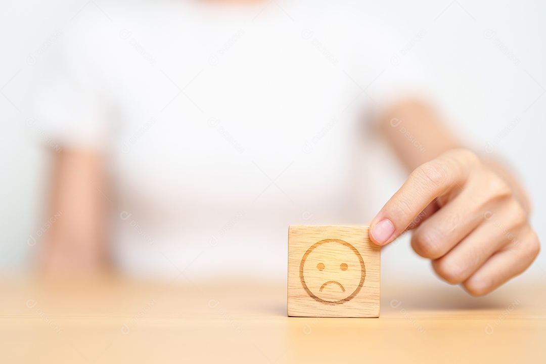 Mão escolhendo rosto irritado infeliz do bloco Emoção. avaliação do cliente, experiência ruim, feedback negativo, satisfação