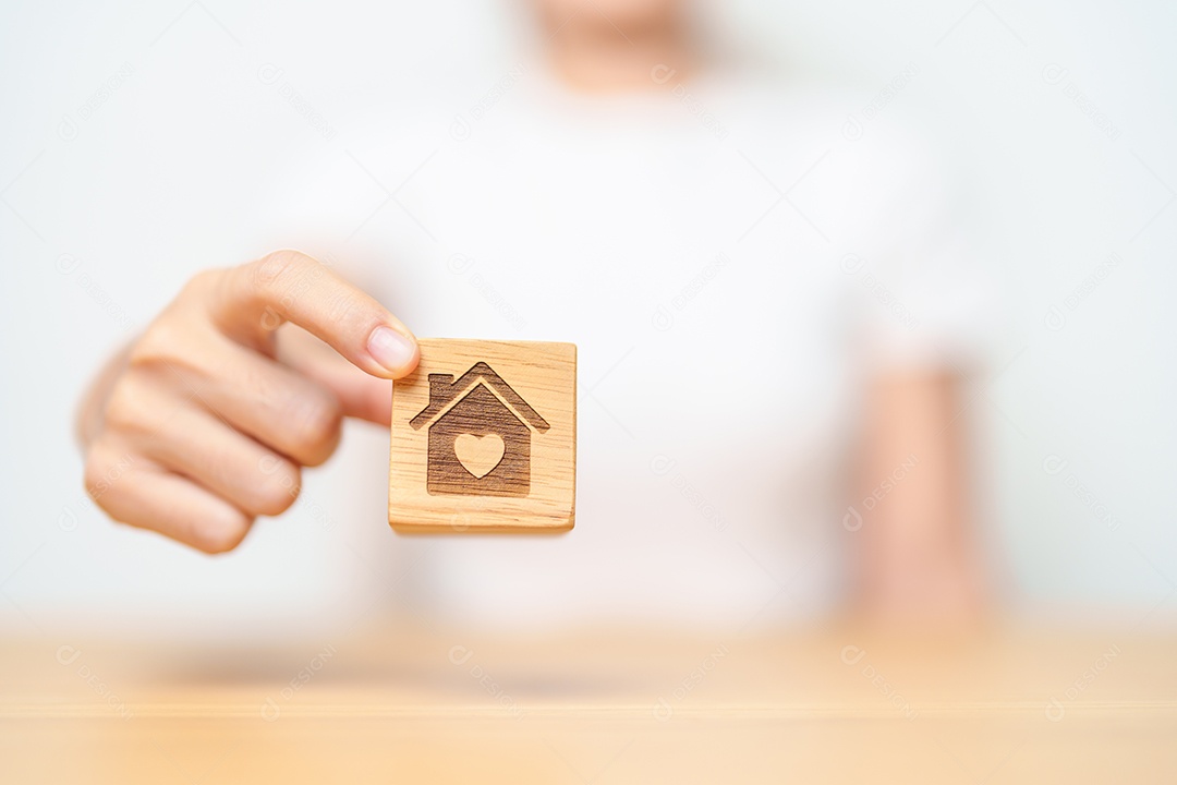 Mão segurando casa com bloco cardíaco. Investimento imobiliário, hipoteca de casa, imposto imobiliário, sem-abrigo