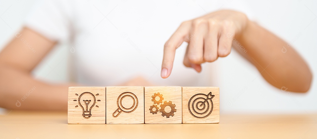 Mão de uma mulher segurando o alvo de dardos acima do bloco de ícones Gear, ampliação e lâmpada.