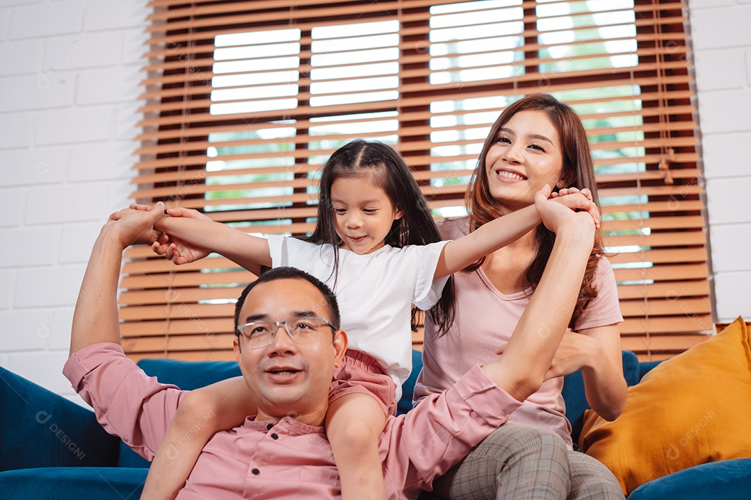 Feliz família asiática aproveitando o fim de semana relaxa no sofá brincando juntos em casa.