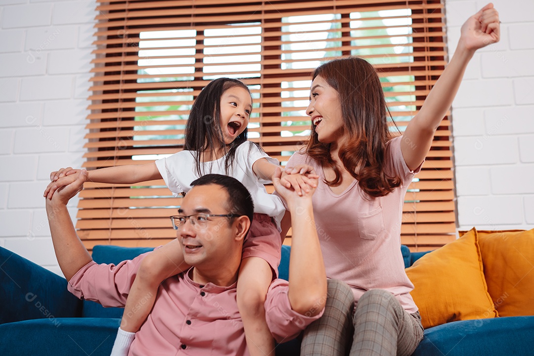 Feliz família asiática aproveitando o fim de semana relaxa no sofá brincando juntos em casa.