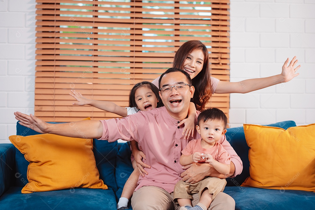 Feliz família asiática aproveitando o fim de semana relaxa no sofá brincando juntos em casa.