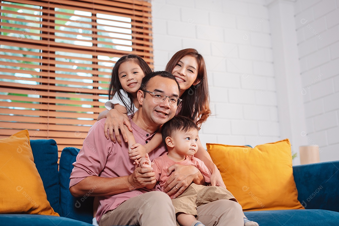 Feliz família asiática aproveitando o fim de semana relaxa no sofá brincando juntos em casa.