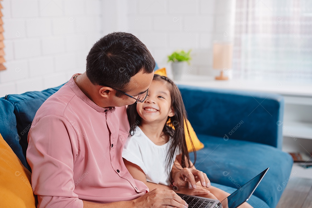 Filha asiática bonitinha com o pai trabalhando no laptop em casa