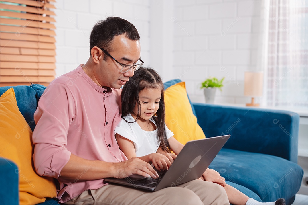 Filha asiática bonitinha com o pai trabalhando no laptop em casa