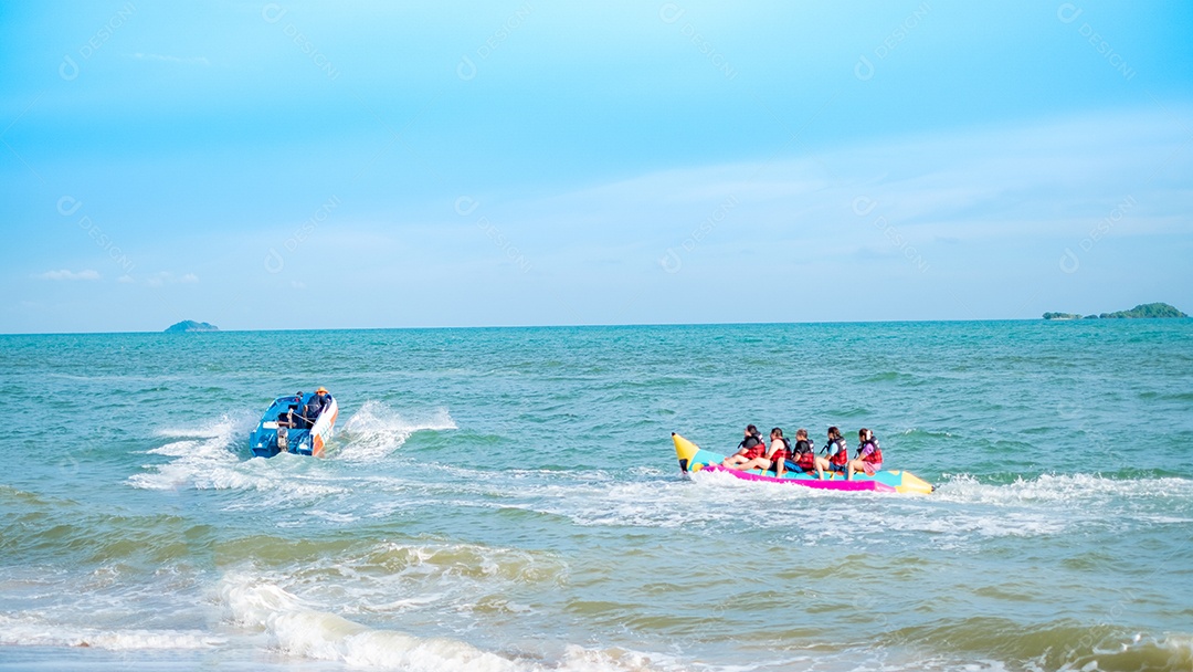 Pessoas andando de banana boat na praia