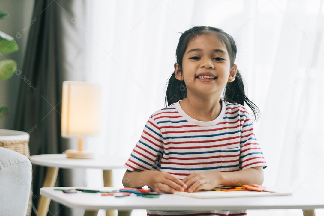 Linda garotinha fazendo atividades sobre a mesa