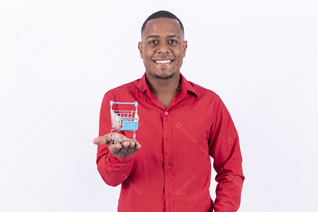 Homem negro sorridente segurando mini carrinho de compras
