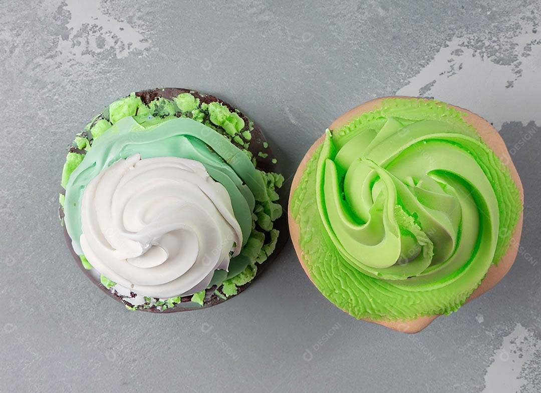 Cupcake com cobertura verde e branca sob fundo isolado